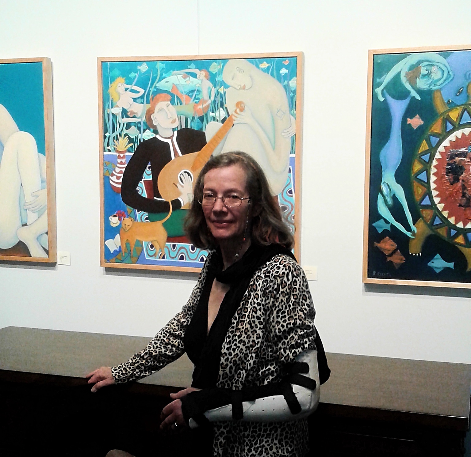 Bea Garth in front her painting The Music Genie, copyright 2018 at the Gallery @ Cerulean feb 2018